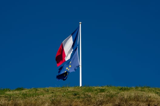 French and European flags flapping in the wind