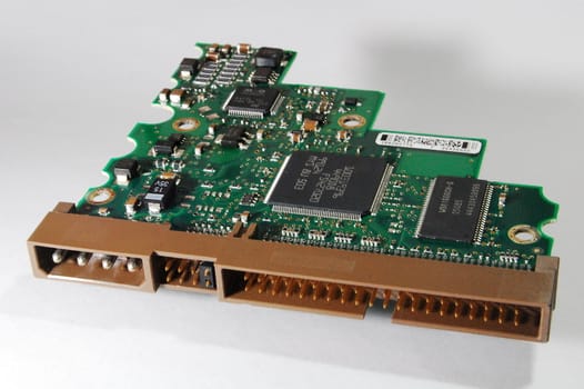 Electronic control board of modern (circa 2009) desktop computer 3.5 inch IDE hard drive (fixed disc), showing integrated circuits (IC's or chips), electrical interconnects/interfaces, and other electronic components.