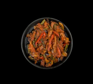 Roasted meat and vegetables at pan on a black background