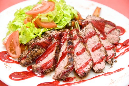 Roasted Beef meat at cranberries sauce with vegetables