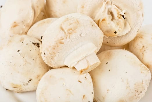 Mushrooms, champignons at plate isolated on a white background
