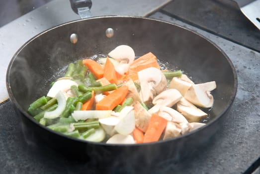 Frying vegetables on the pan with smoking
