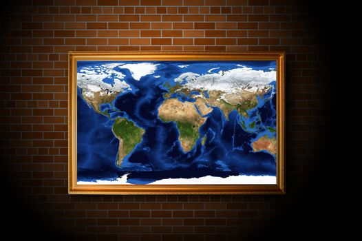 frame with earth map hanging on the brick wall