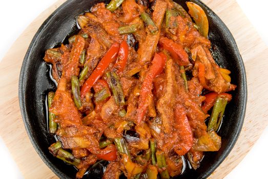 Roasted meat and vegetables at pan on a white background