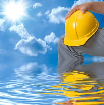 Closeup of Yellow helmet at builder hands on building background