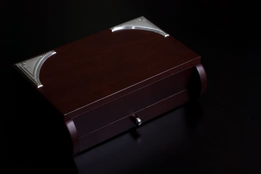 Brown wooden box on a dark background