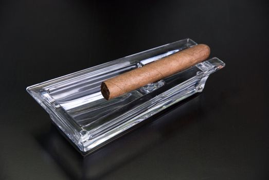 Cigar at ashtray isolated on a black back