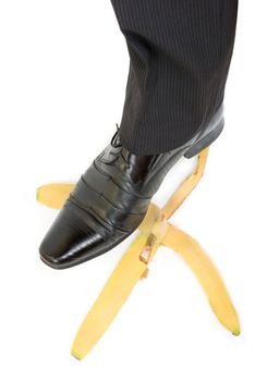 Business boot to step on a banana skin on a white