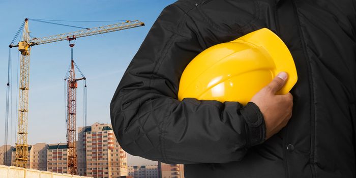 Closeup of builder with helmet on building background