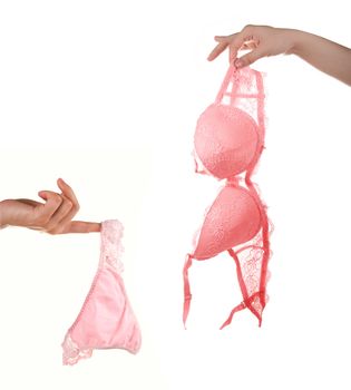 Woman hands hold pink bra and pants isolated on white background