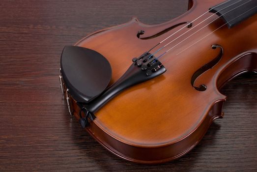 violin on a brown wooden background closeup