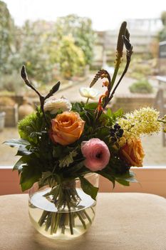 Bouquet of flowers in window with view to garden in background