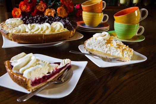 Different Dutch pastry or Limburgian flans with cups, mugs and flowers prepared for a party - horizontal