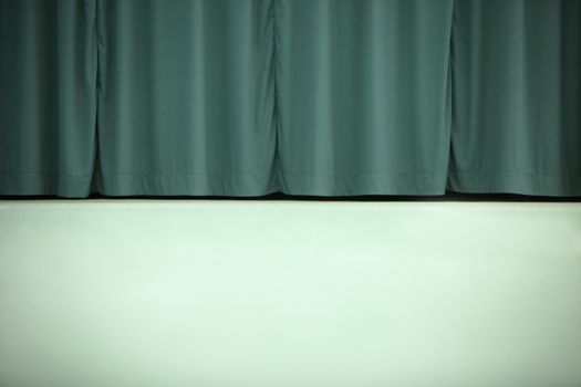 A dual color background image of a light green wall and dark green curtains.