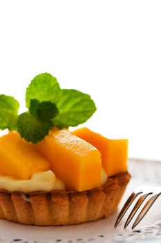 French tart with mango and vanilla pudding on white background as a studio shot