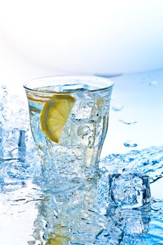 cold soda drink with ice and lemon slashed by water