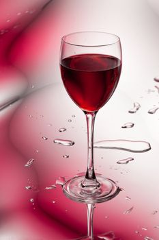 glass of red wine on abstract colorful background