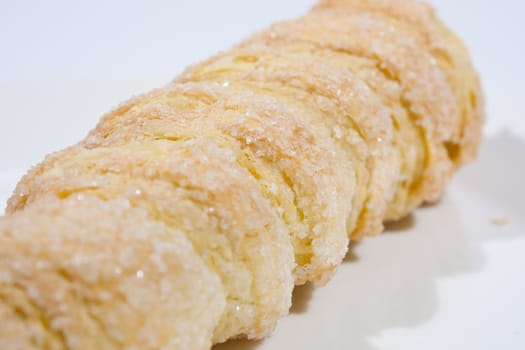 Hard bread with cream Form of a spiral The white background.