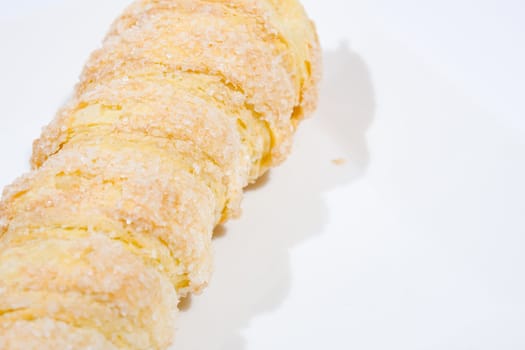 Hard bread with cream Form of a spiral The white background.