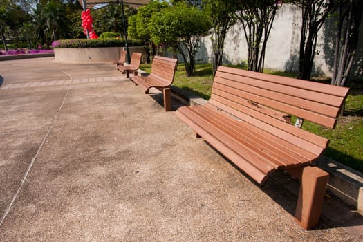 Wooden bench in the park on your holiday tree shade.