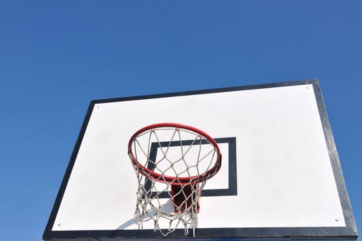 Outdoor basketball table over a blue sky