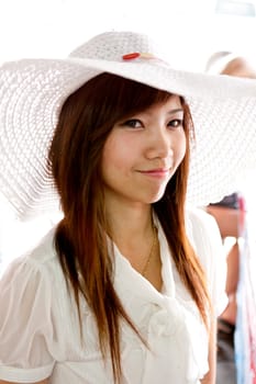 smiling young thai girl and white hat in travel.