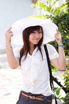 smiling young thai girl and white hat in travel.