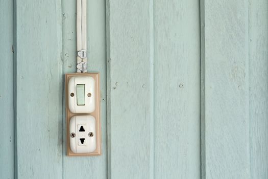 Switch and power outlet on green wood wall