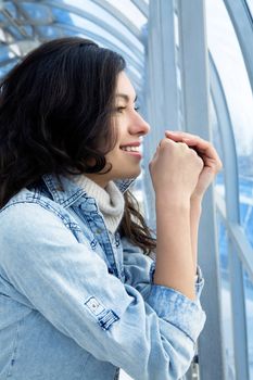 attractive girl in a denim jacket in a modern building against windows