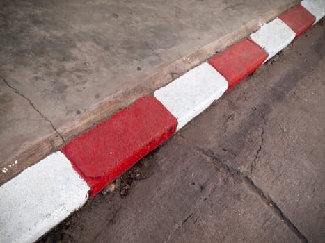 White and red paint on the footpath no parking