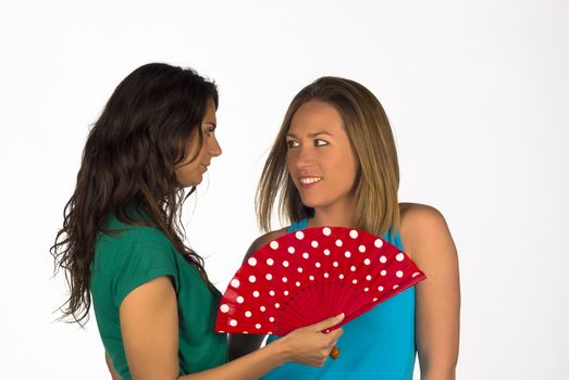 Two girls using a traditional red fan