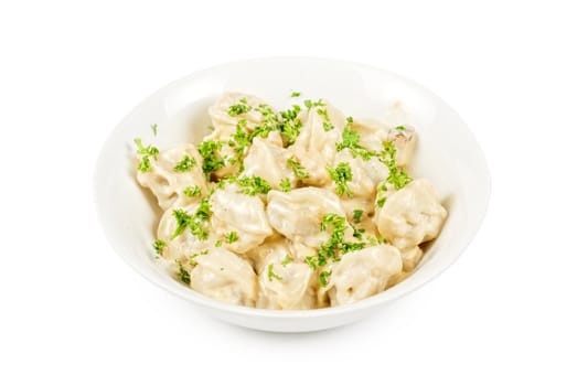 meat dumplings with greens on a white