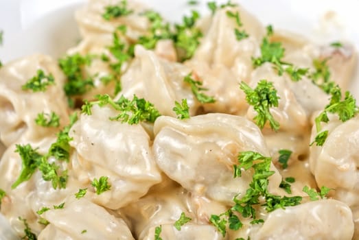 meat dumplings with greens on a white