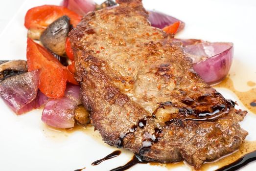Roasted beef steak with vegetable closeup at plate