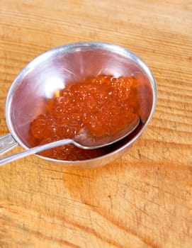 Red caviar closeup at wooden board