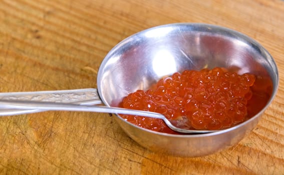 Red caviar closeup at wooden board