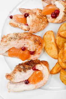 Roast chicken meat with apricot and potato closeup