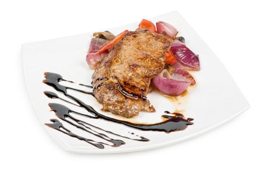 Roasted beef steak with vegetable closeup at plate