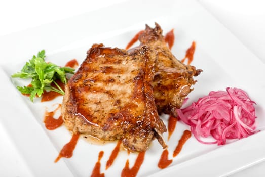 Roasted pork meat at plate with greens