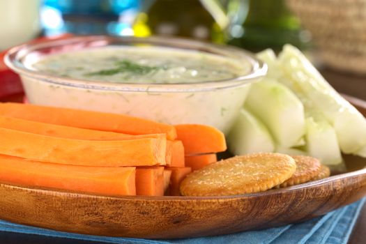 Fresh carrots, cucumbers and pepper and crackers with tzatziki dip (Selective Focus, Focus on the front of the cracker and the front of the upper front carrot)