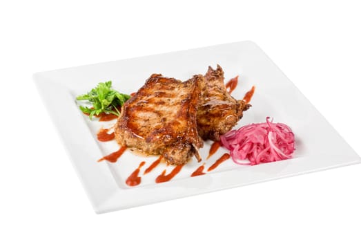 Roasted pork meat at plate with greens