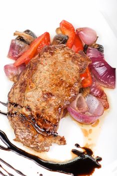 Roasted beef steak with vegetable closeup at plate