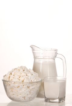 dish with cottage cheese and glass with milk