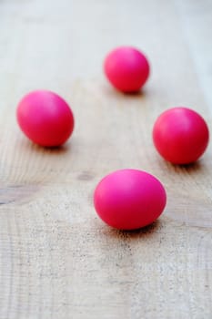 An image of four purple eggs on the wood