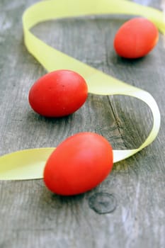 An image of three red eggs and a yellow stripe