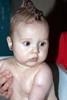 Bathing a cute little baby in the bath.
