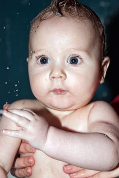 Bathing a cute little baby in the bath.