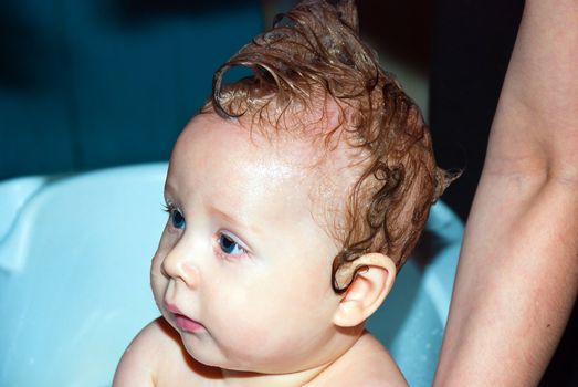 Bathing a cute little baby in the bath.
