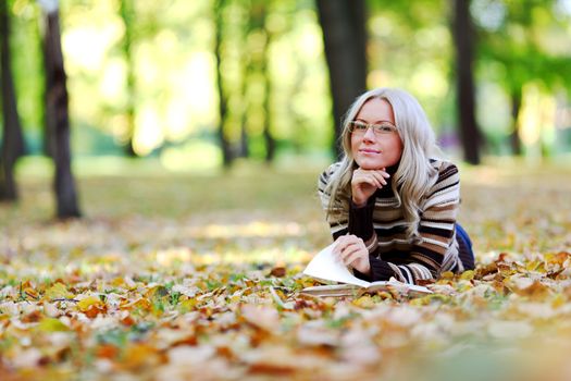 woman read the book in autumn park