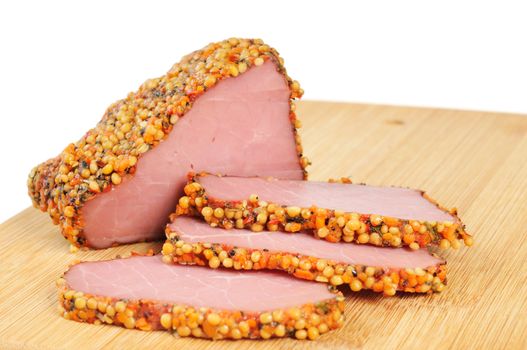 Piece of a ham with spices on a wooden board. Onwhite background.